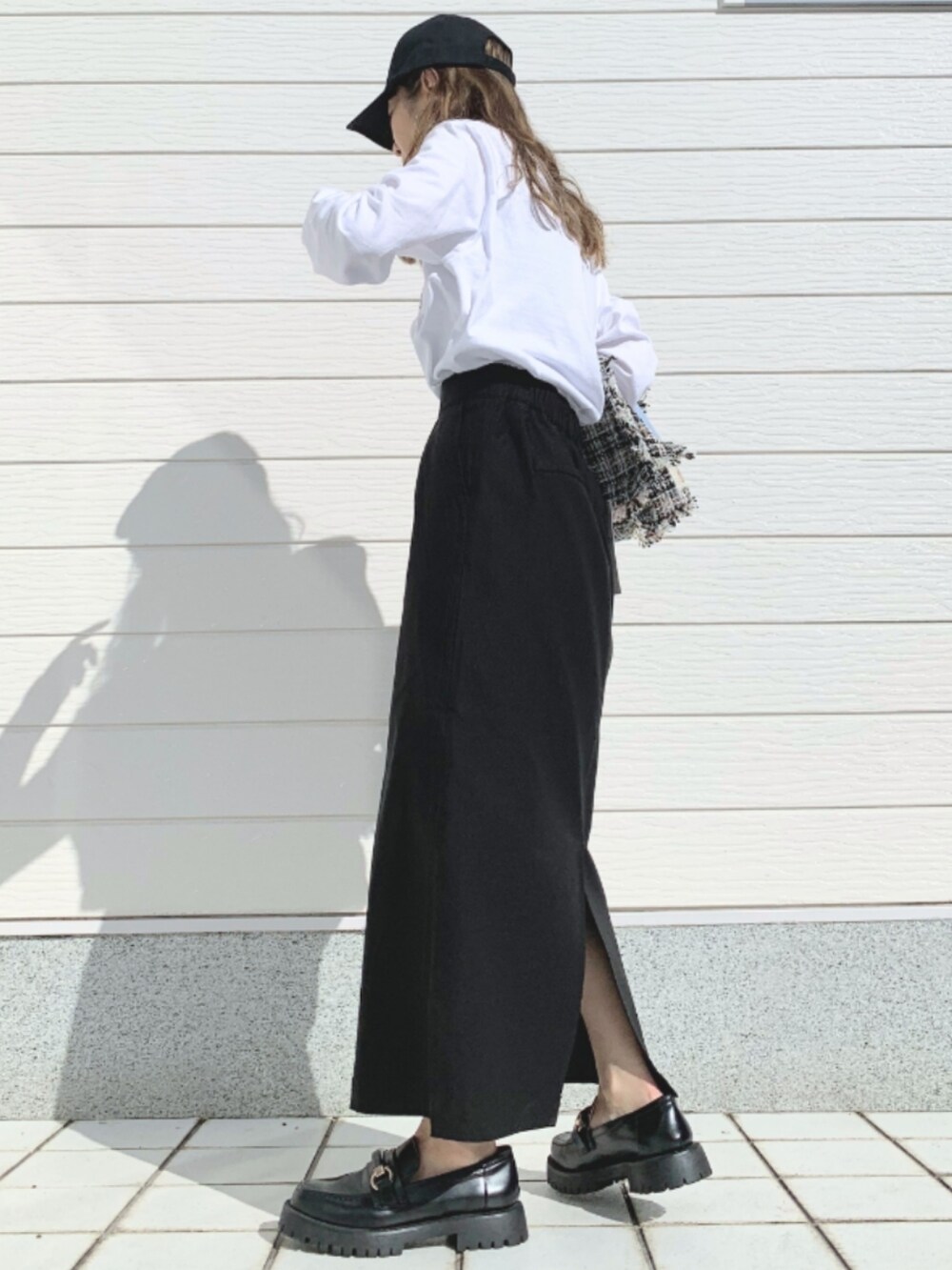 ブラック系のローファー、ブラック系のトートバッグ、ホワイト系のTシャツ/カットソーを着用したレディースの春コーディネートの4枚目の写真