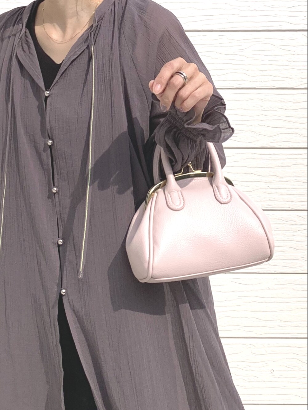 ピンク系のショルダーバッグ、ブラウン系のワンピースを着用したレディースの春コーディネートの4枚目の写真