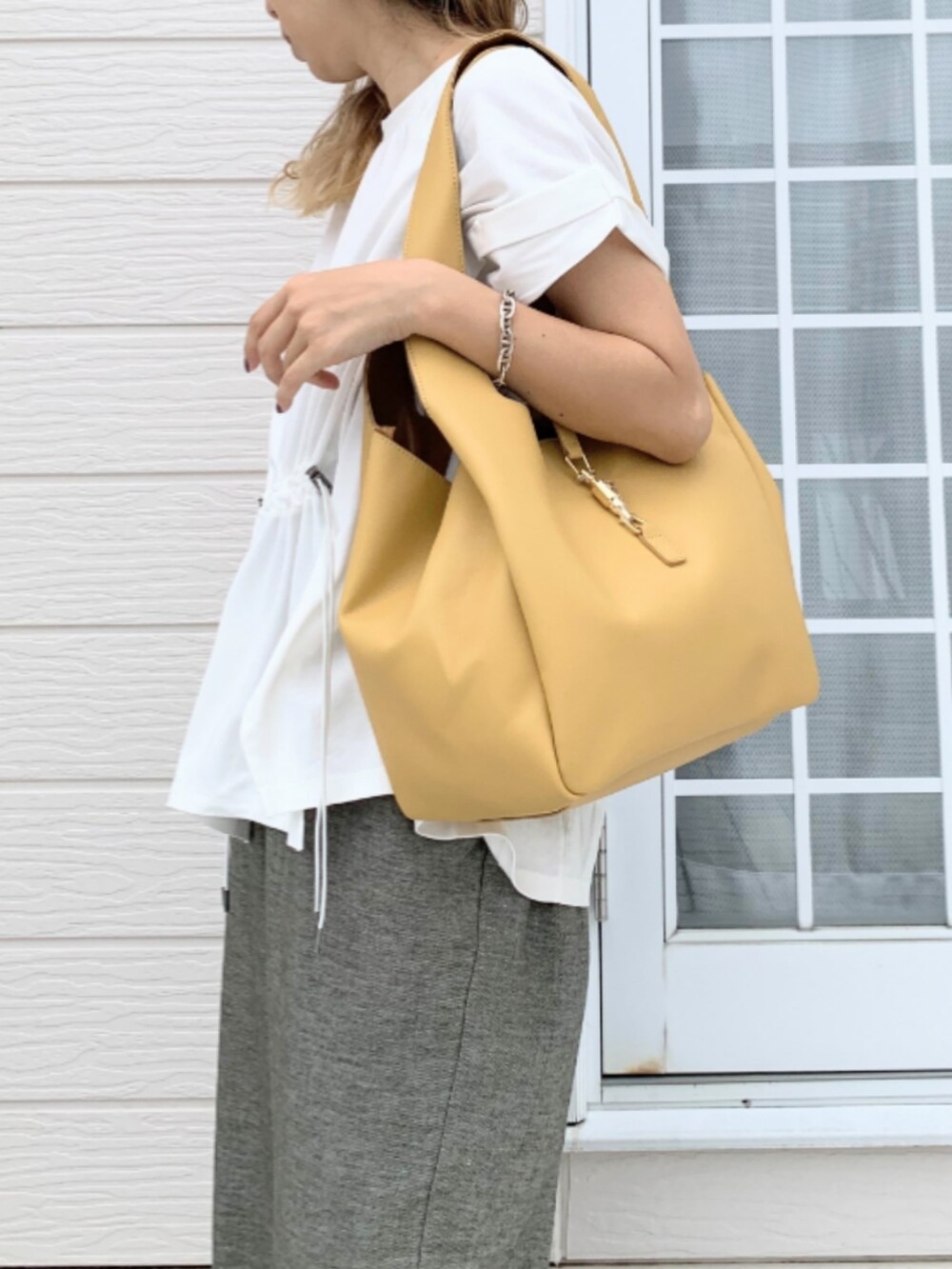 ブラック系のその他パンツ、ホワイト系のTシャツ/カットソー、イエロー系のトートバッグを着用したレディースの夏コーディネートの5枚目の写真