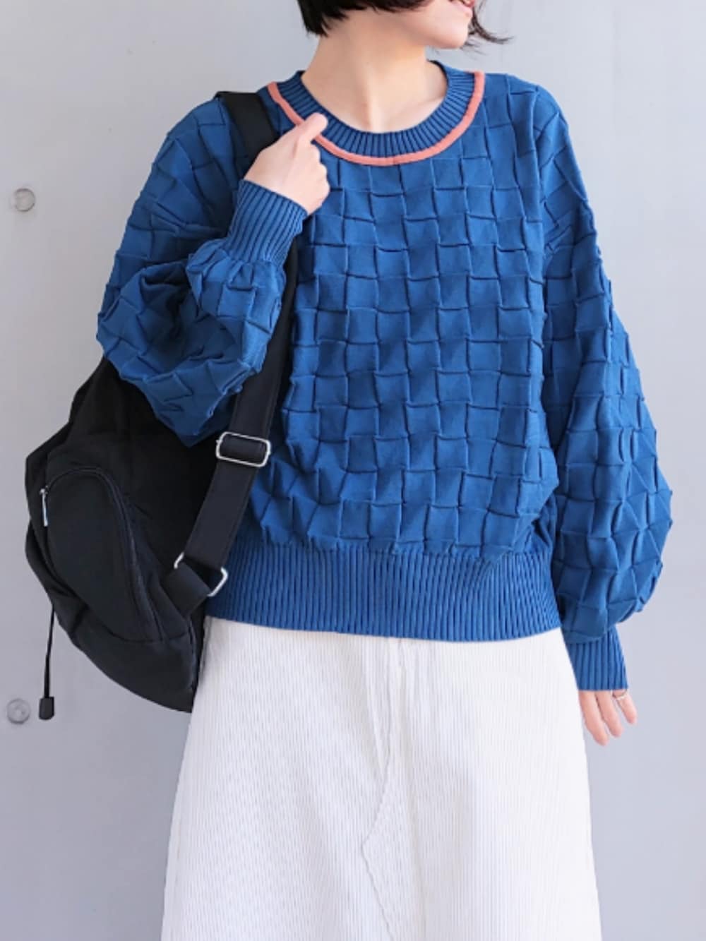 ブラック系のバックパック/リュック、ホワイト系のスカート、ブラック系のスニーカーを着用したレディースの冬コーディネートの3枚目の写真