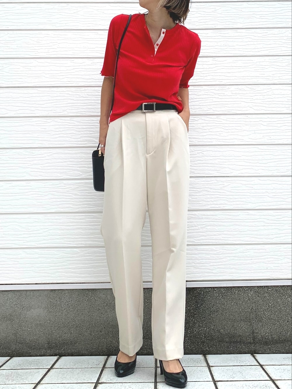 グレー系のその他パンツ、レッド系のTシャツ/カットソー、ブラック系のショルダーバッグを着用したレディースの秋コーディネートの2枚目の写真