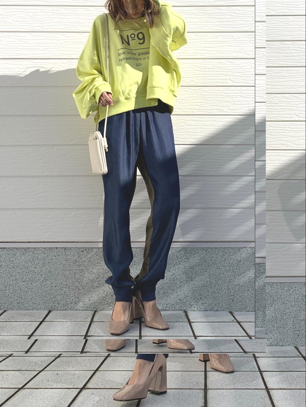 グリーン系のデニムパンツ、ホワイト系のショルダーバッグ、イエロー系のスウェットを着用したレディースの冬コーディネートの3枚目の写真