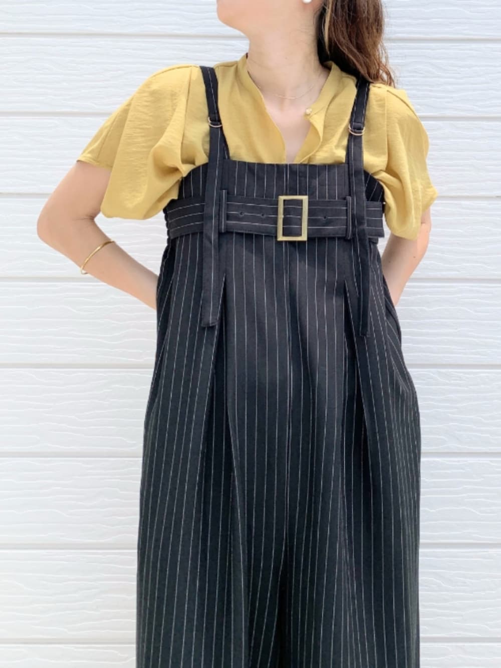 ブラウン系のサンダル、イエロー系のシャツ/ブラウス、ブラック系のサロペット/オーバーオールを着用したレディースの夏コーディネートの3枚目の写真