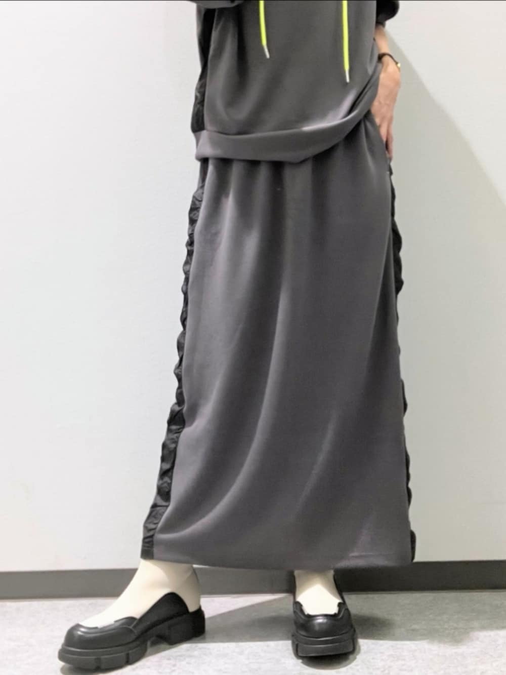グレー系のスカート、グレー系のパーカー、ホワイト系のブーツを着用したレディースの秋コーディネートの5枚目の写真