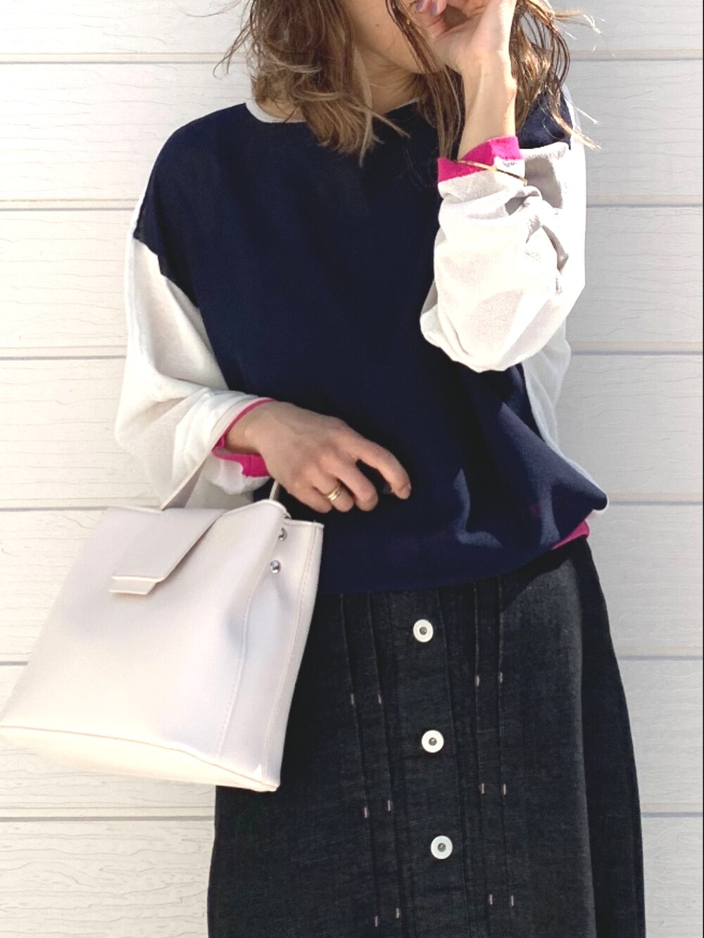 ホワイト系のハンドバッグ、ブラック系のデニムスカート、ホワイト系のカーディガン/ボレロを着用したレディースの春コーディネートの4枚目の写真