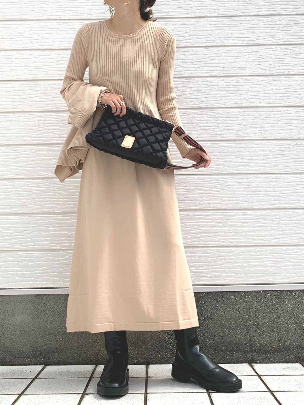ブラック系のショルダーバッグ、ベージュ系のワンピース、シルバー系のブレスレットを着用したレディースの秋コーディネートの2枚目の写真