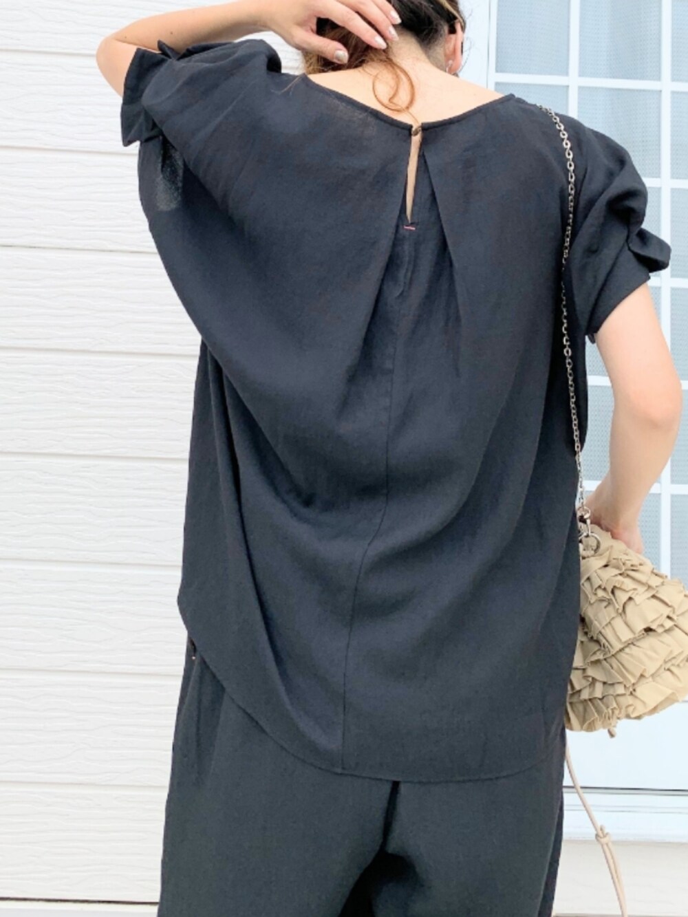 ベージュ系のクラッチバッグ、イエロー系のサンダル、ブラック系のシャツ/ブラウスを着用したレディースの夏コーディネートの5枚目の写真