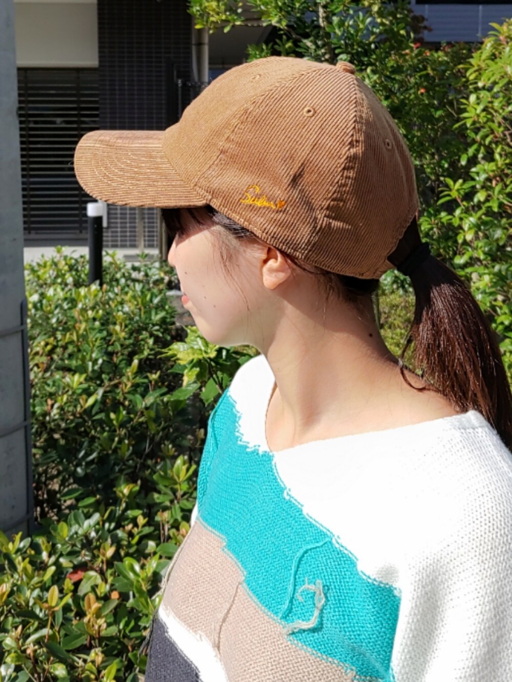 ホワイト系のスニーカー、ホワイト系のニット/セーター、ブラック系のトートバッグを着用したレディースの秋コーディネートの3枚目の写真