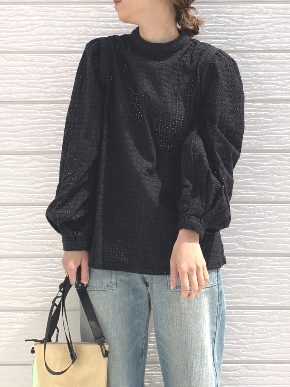 ブルー系のデニムパンツ、ベージュ系のショルダーバッグ、ブラック系のシャツ/ブラウスを着用したレディースの春コーディネートの3枚目の写真