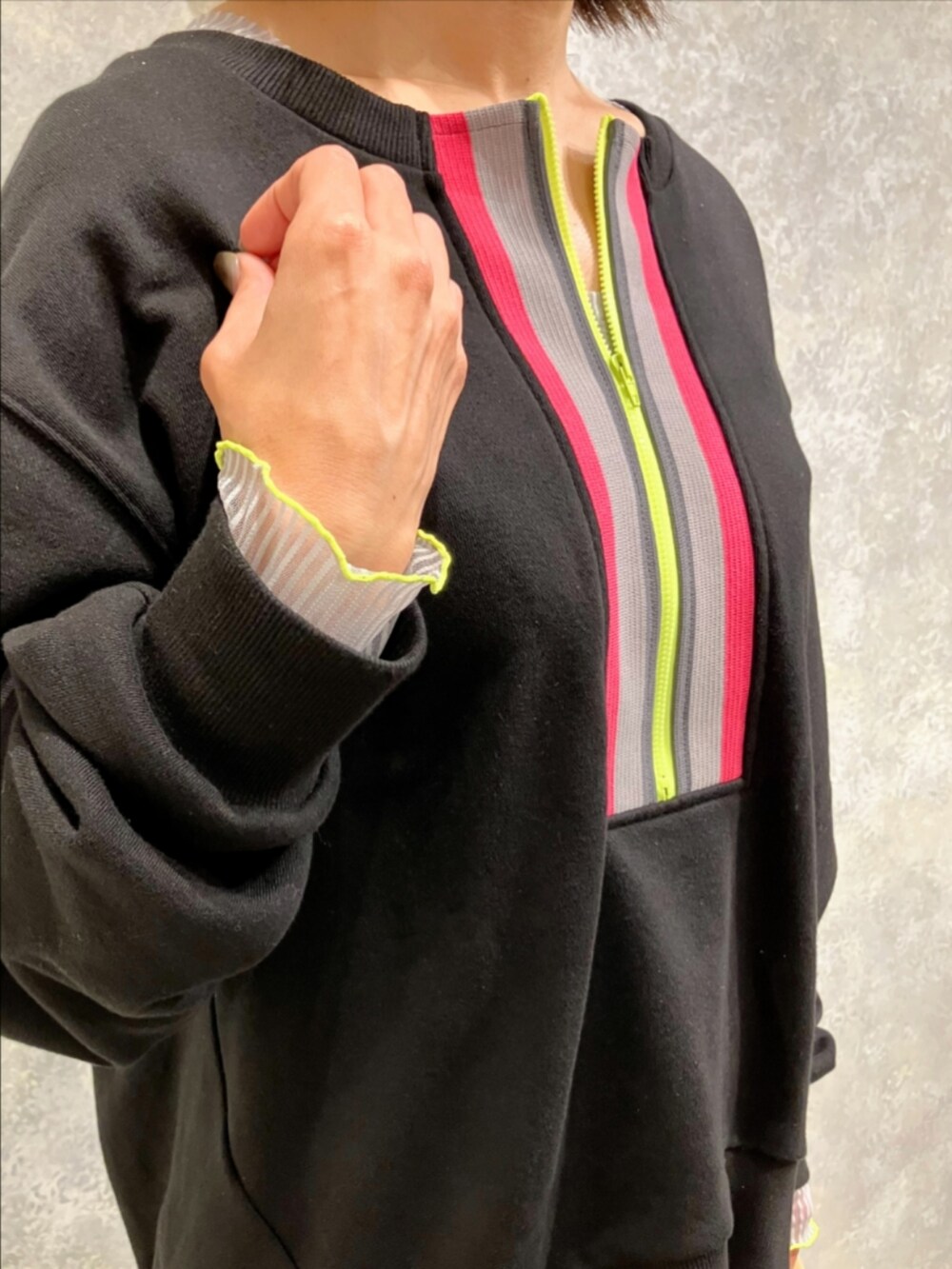 グリーン系のスカート、ベージュ系のトートバッグ、ブラック系のスウェットを着用したレディースの秋コーディネートの4枚目の写真