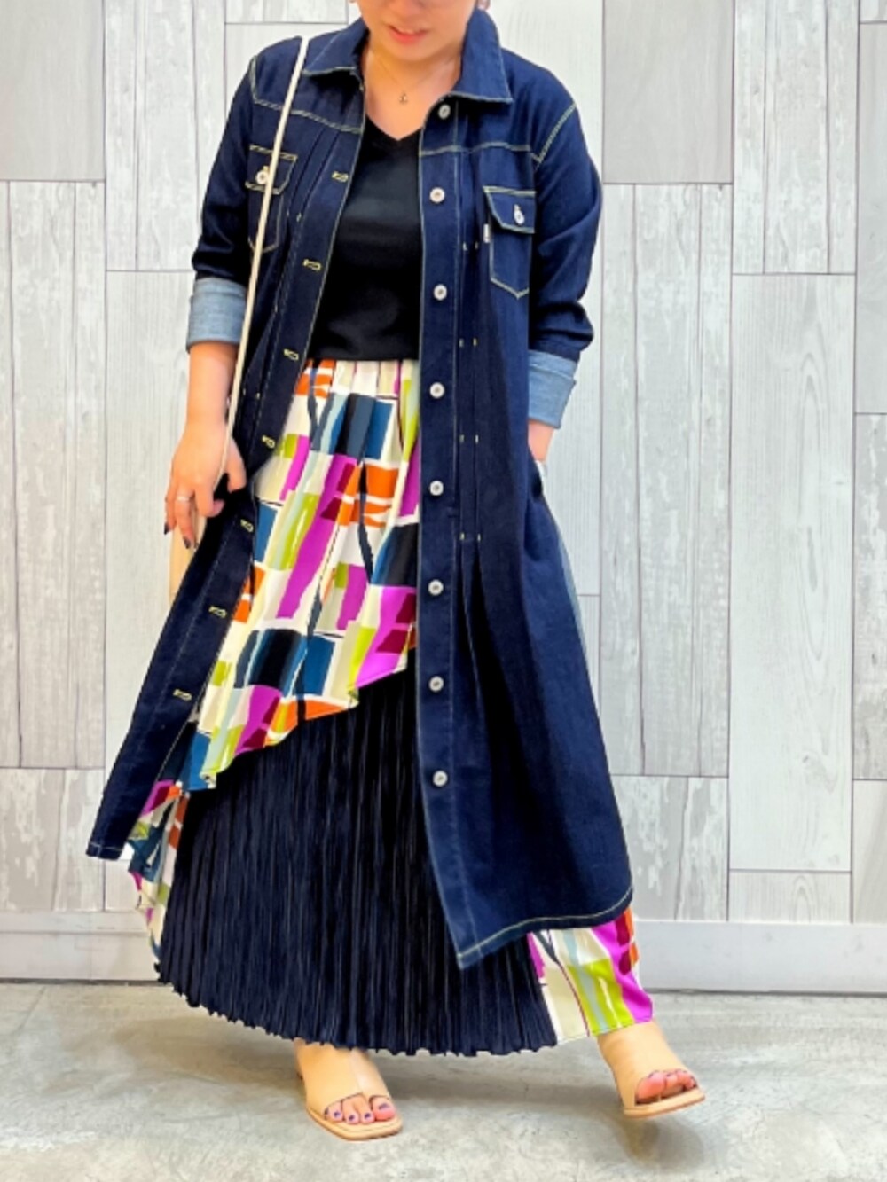 ブルー系のシャツワンピース、ベージュ系のショルダーバッグ、ピンク系のスカートを着用したレディースの秋コーディネートの2枚目の写真