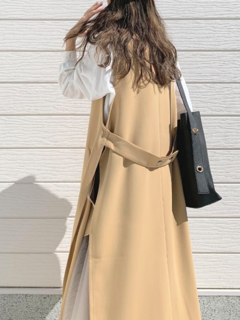 ホワイト系のTシャツ/カットソー、ブラック系のトートバッグ、ゴールド系のスカートを着用したレディースの春コーディネートの5枚目の写真