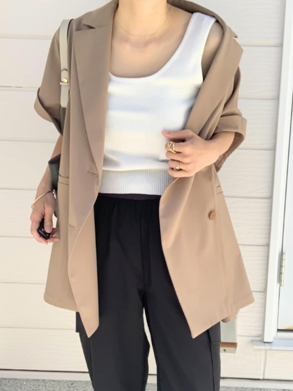 ブラック系のパンプス、ブラック系のカーゴパンツ、ベージュ系のテーラードジャケットを着用したレディースの春コーディネートの5枚目の写真