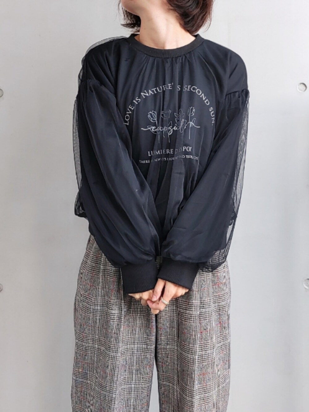 ブラック系のスラックス、ブラック系のスウェット、ホワイト系のボストンバッグを着用したレディースの秋コーディネートの5枚目の写真