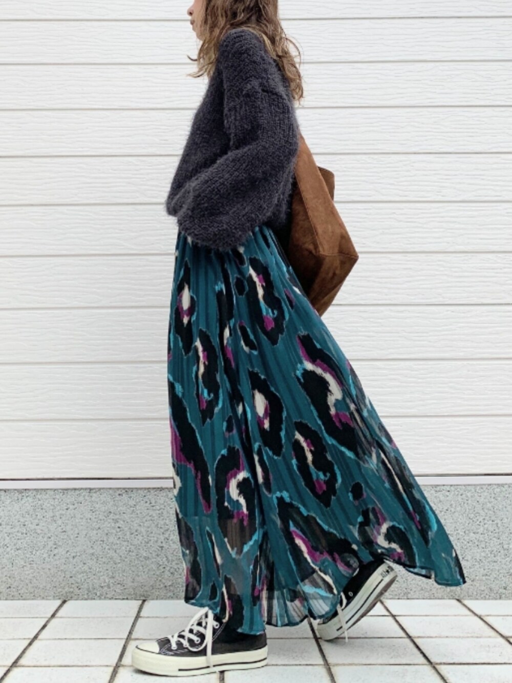 グリーン系のスカート、ブラック系のスニーカー、グレー系のニット/セーターを着用したレディースの秋コーディネートの2枚目の写真