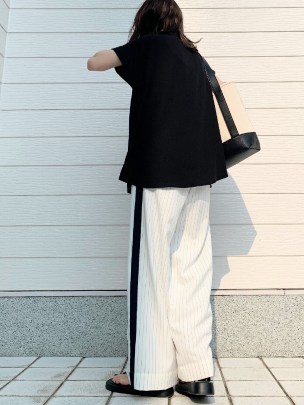 ホワイト系のその他パンツ、ブラック系のシャツ/ブラウス、ブラック系のハンドバッグを着用したレディースの春コーディネートの3枚目の写真