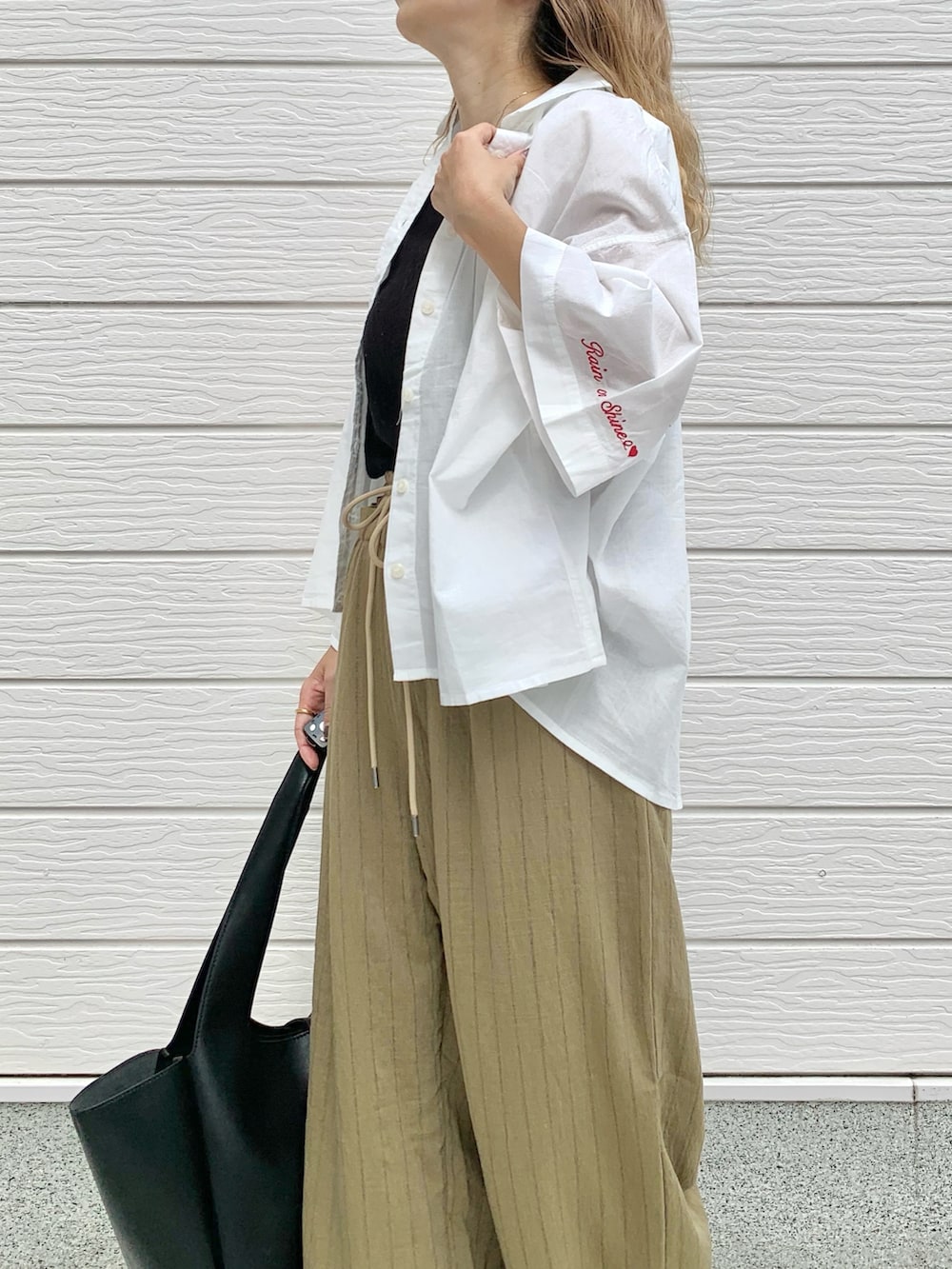 ホワイト系のシャツ/ブラウス、ブラック系のトートバッグ、ブラウン系のその他パンツを着用したレディースの夏コーディネートの3枚目の写真