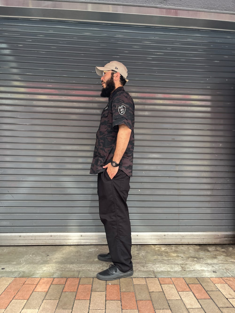 ブラック系のカーゴパンツ、ブラック系のシャツ/ブラウス、ベージュ系の帽子を着用したメンズの夏コーディネートの2枚目の写真