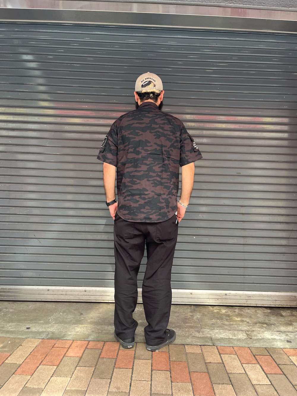 ブラック系のカーゴパンツ、ブラック系のシャツ/ブラウス、ベージュ系の帽子を着用したメンズの夏コーディネートの3枚目の写真