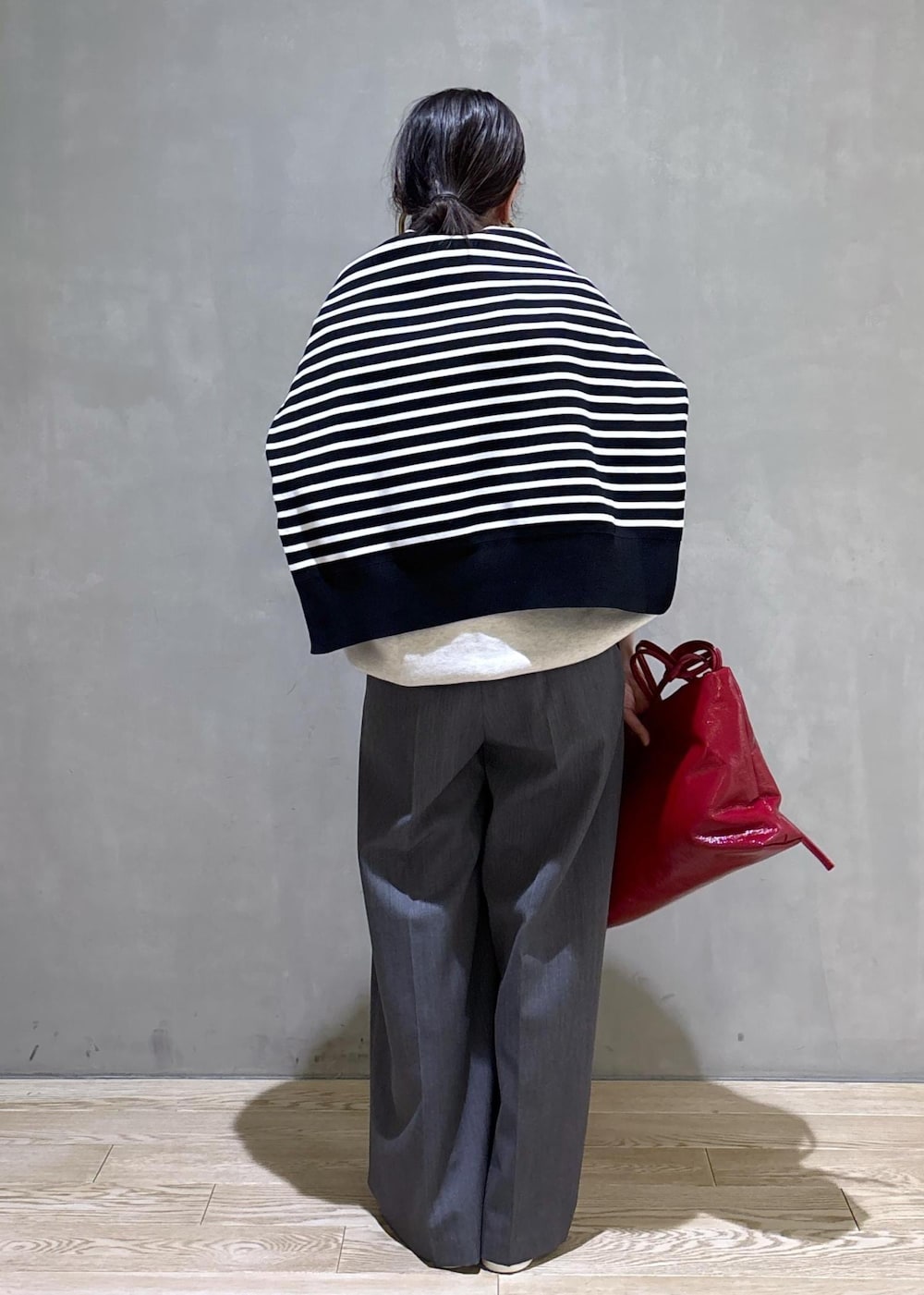 グレー系のスラックス、ホワイト系のスウェット、ブラック系のニット/セーターを着用したレディースの冬コーディネートの5枚目の写真