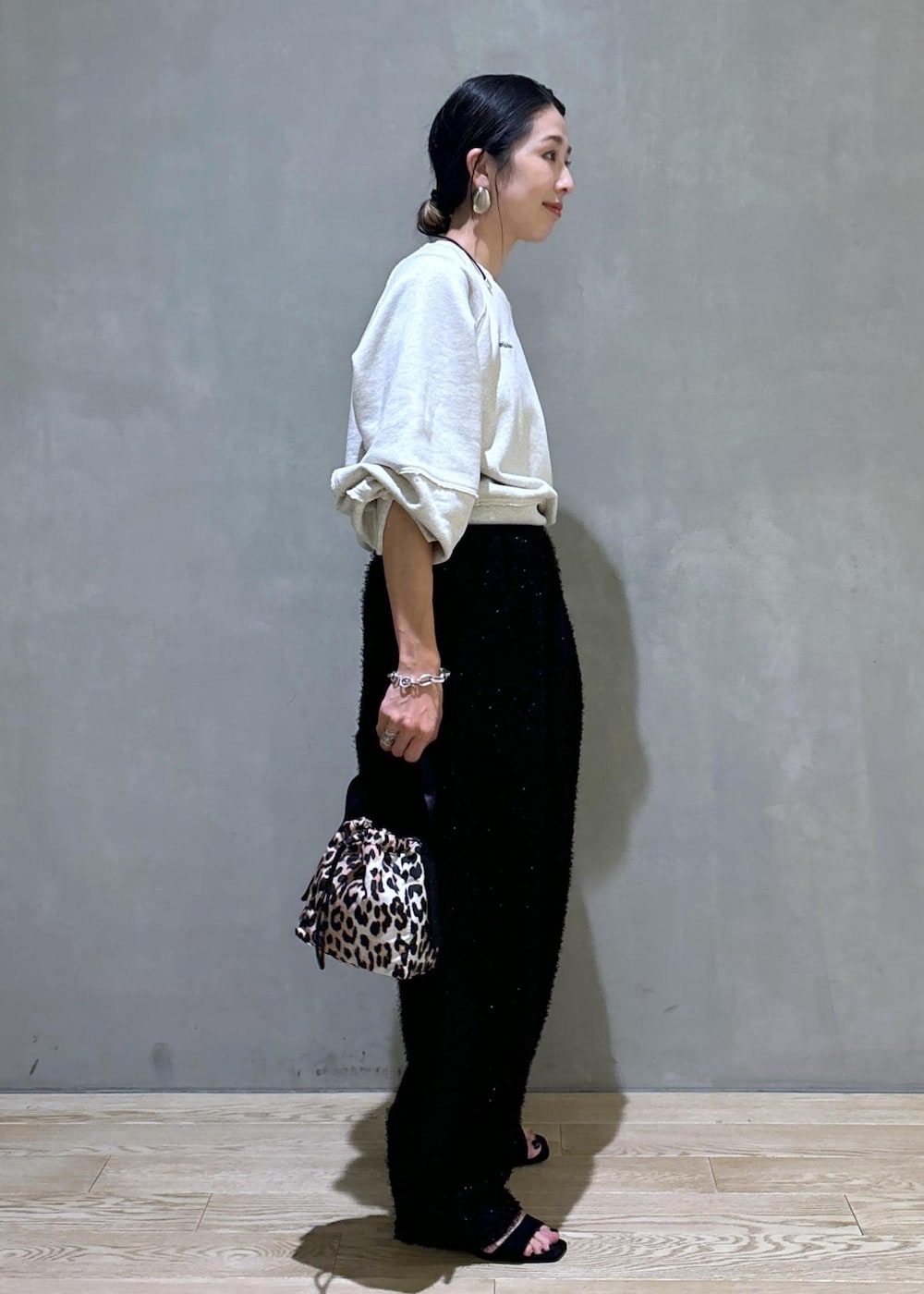 ブラウン系のハンドバッグ、ブラック系のその他パンツ、ホワイト系のスウェットを着用したレディースの夏コーディネートの3枚目の写真