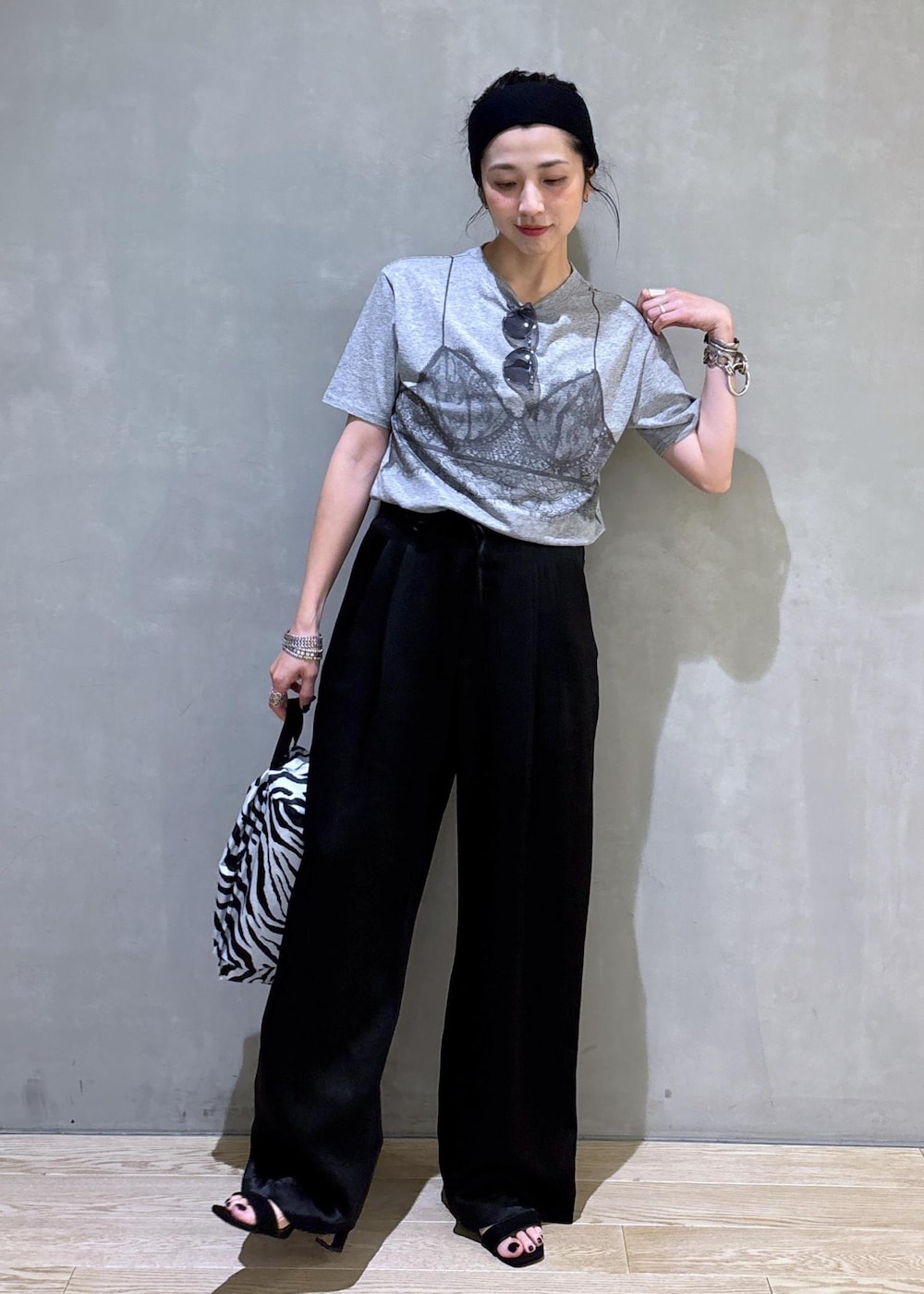 グレー系のTシャツ/カットソー、ブラック系のスラックス、ホワイト系のネックレスを着用したレディースの夏コーディネートの7枚目の写真