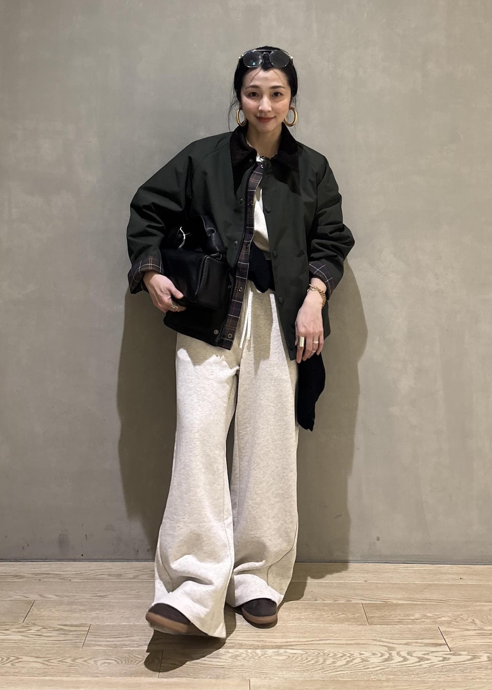 ブラック系のハンドバッグ、グリーン系のその他アウター、ホワイト系のその他パンツを着用したレディースの冬コーディネートの7枚目の写真