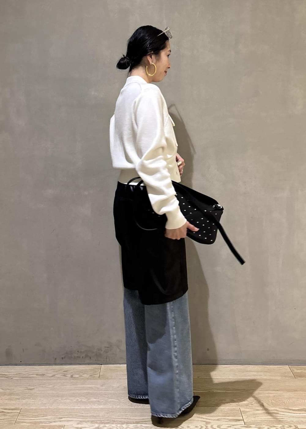 ブラック系のサンダル、ブルー系のデニムパンツ、ブラック系のダウンジャケット/コートを着用したレディースの冬コーディネートの6枚目の写真