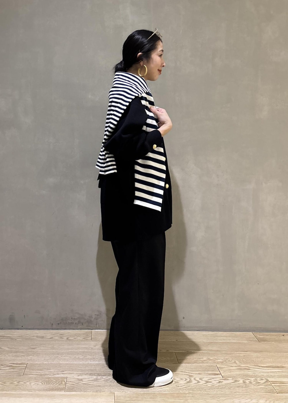 ブルー系のTシャツ/カットソー、ブラック系のカーディガン/ボレロ、ブラック系のスラックスを着用したレディースの冬コーディネートの8枚目の写真