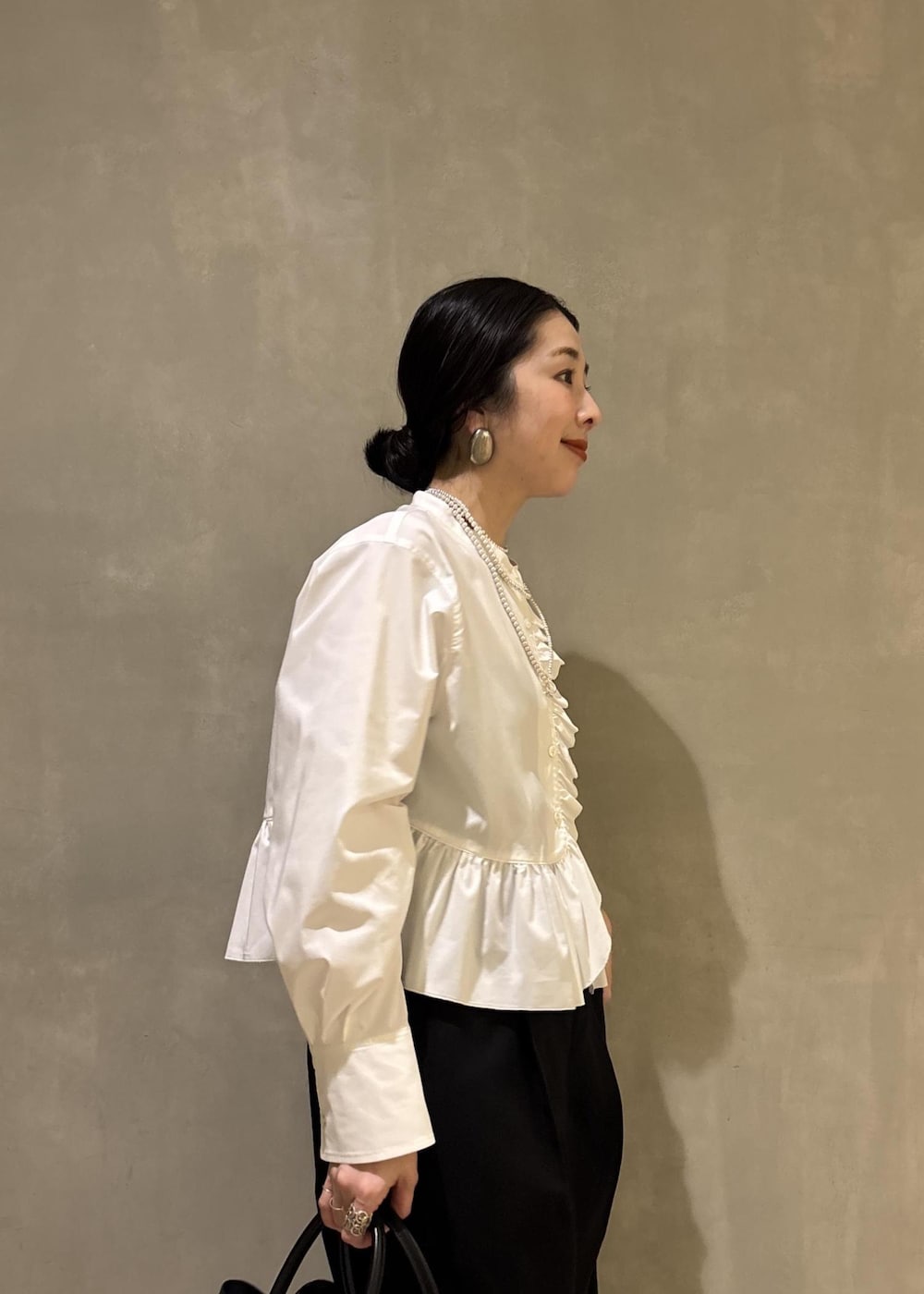 ホワイト系のシャツ/ブラウス、ブラック系のスラックス、ブラック系のトートバッグを着用したレディースの冬コーディネートの8枚目の写真