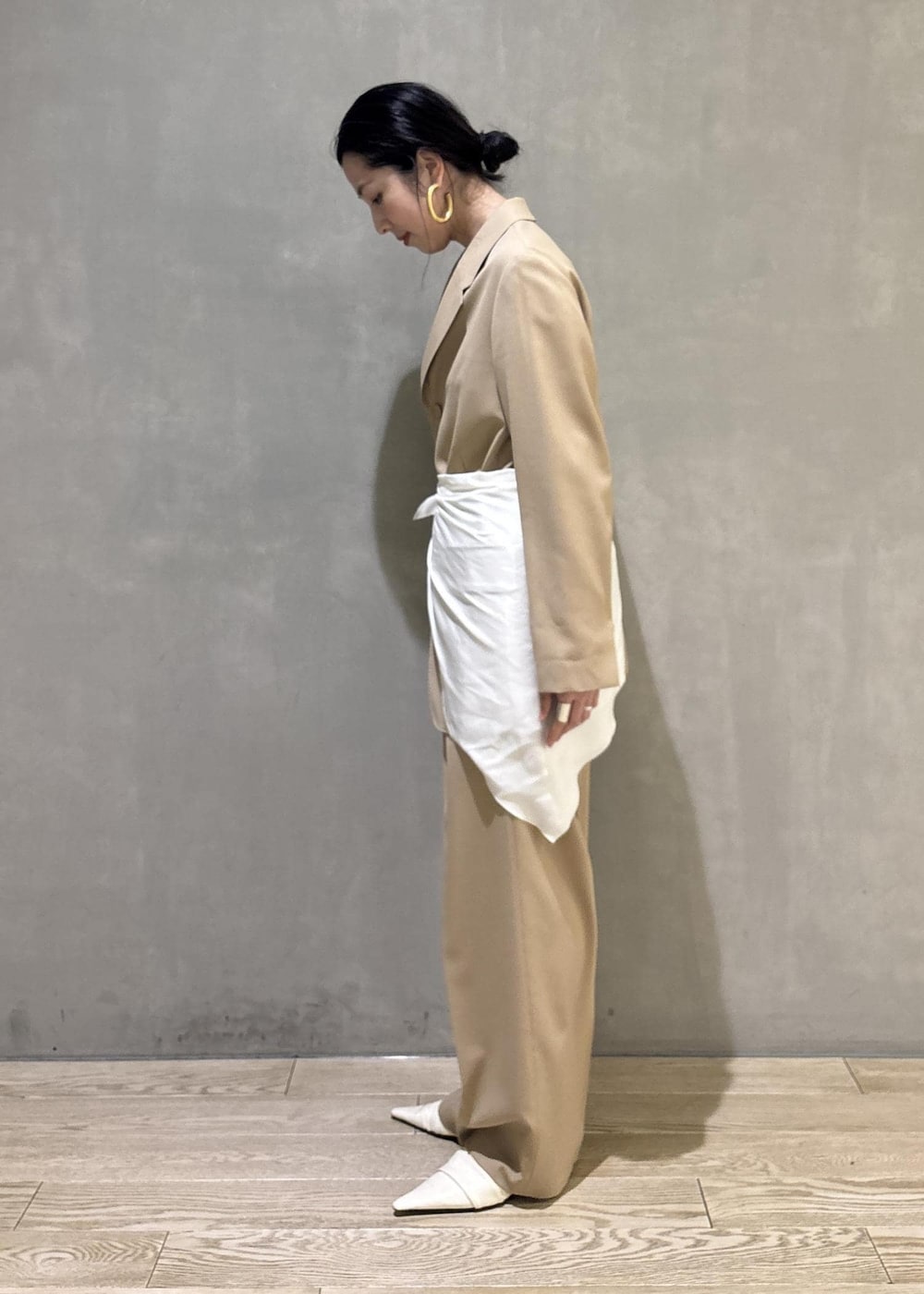 ベージュ系のテーラードジャケット、ホワイト系のシャツ/ブラウス、ベージュ系のスラックスを着用したレディースの冬コーディネートの6枚目の写真