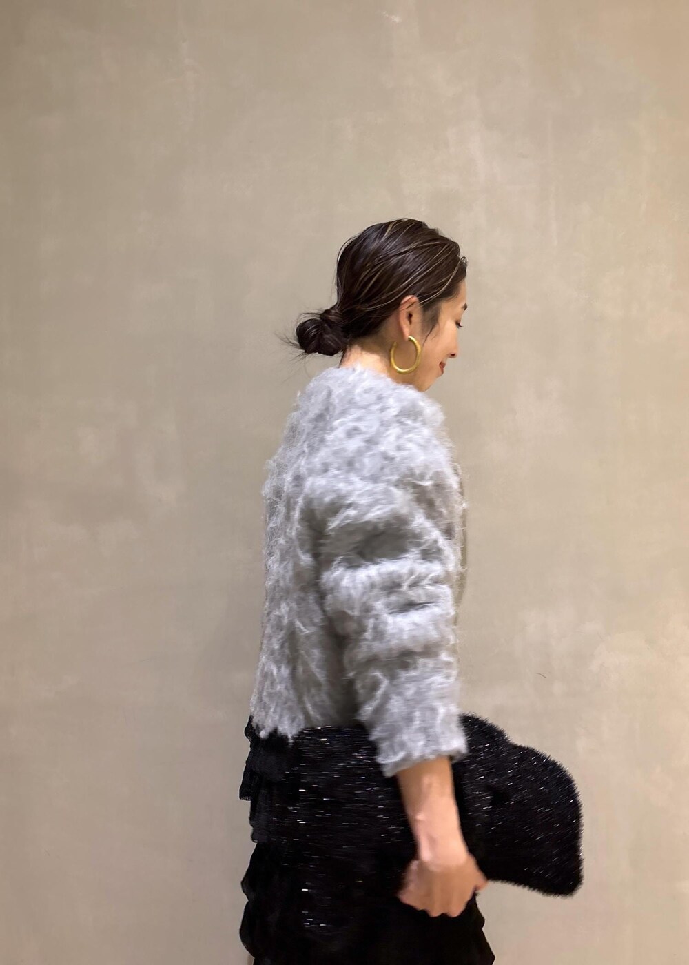 ブラック系のスカート、グレー系のカーディガン/ボレロ、ブラック系のトートバッグを着用したレディースの冬コーディネートの8枚目の写真