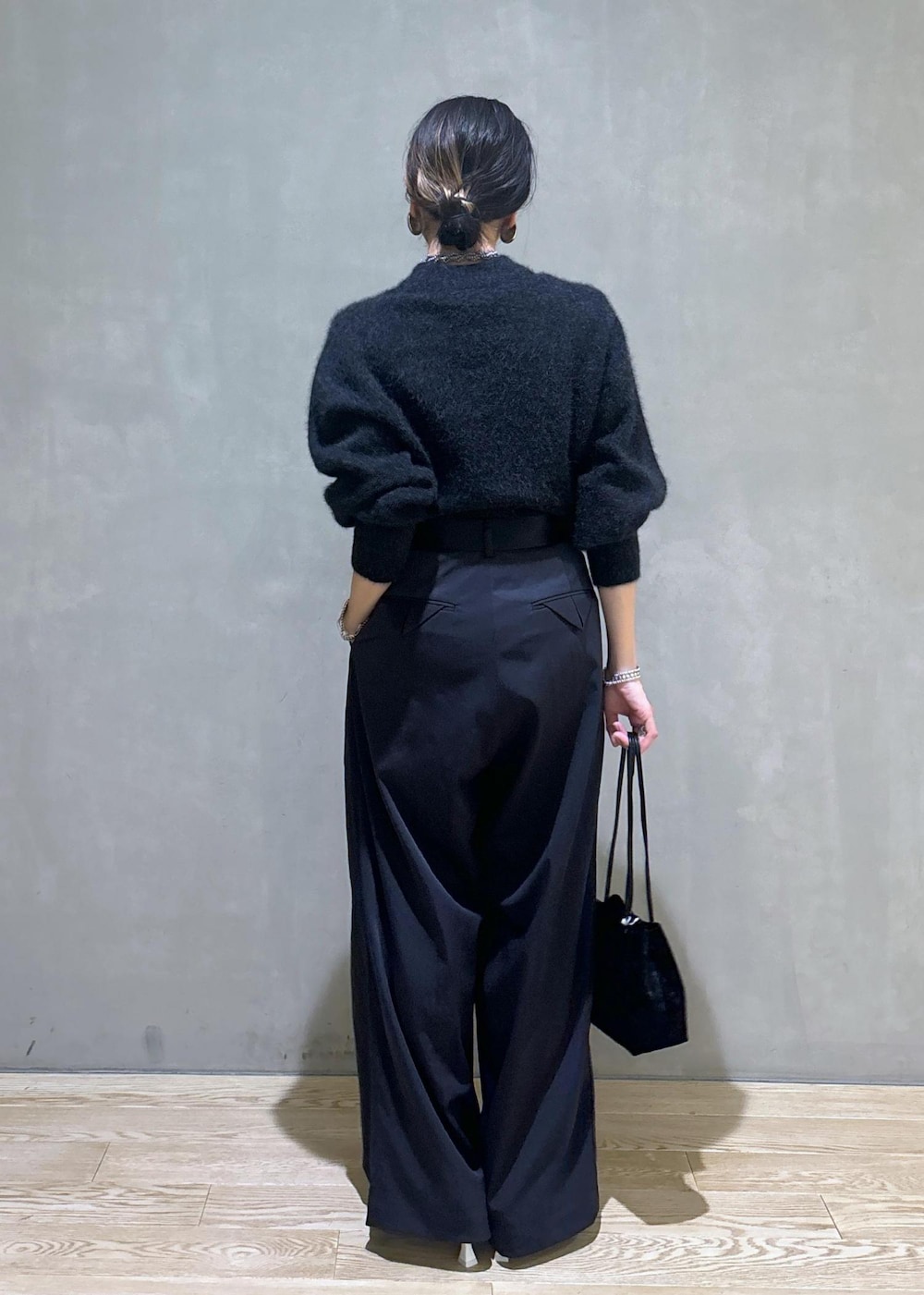 ホワイト系のパンプス、ブラック系のスラックス、グレー系のニット/セーターを着用したレディースの秋コーディネートの4枚目の写真