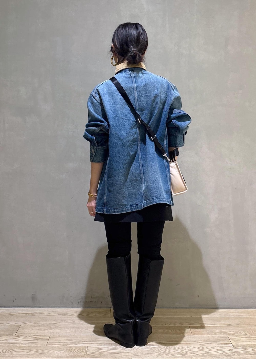 ベージュ系のトートバッグ、ブラック系のブーツ、ブラック系のスカートを着用したレディースの冬コーディネートの5枚目の写真