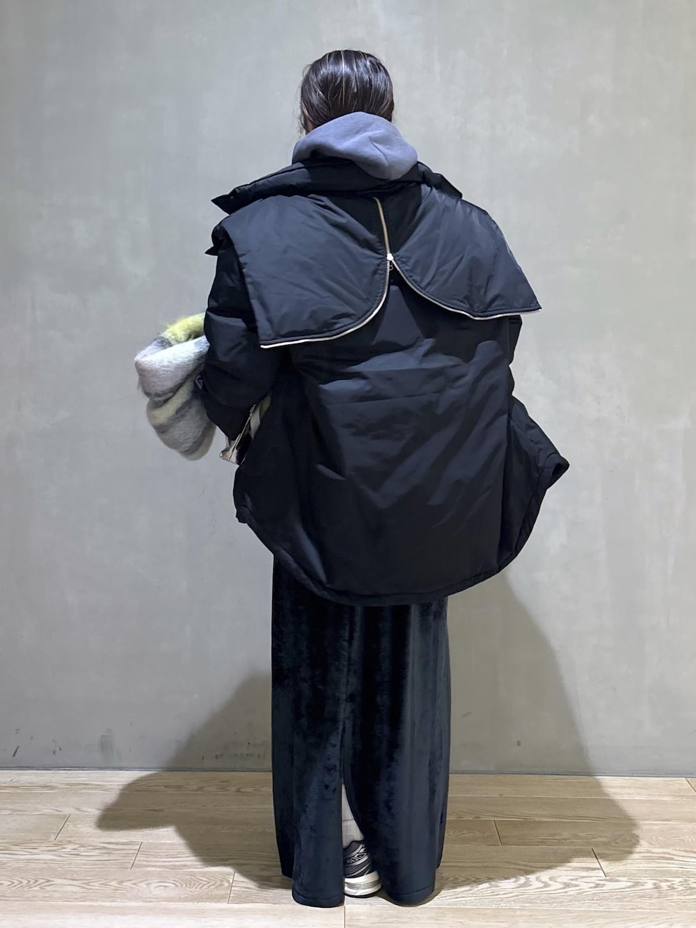 グレー系のスニーカー、ブラック系のスカート、グレー系のパーカーを着用したレディースの冬コーディネートの4枚目の写真