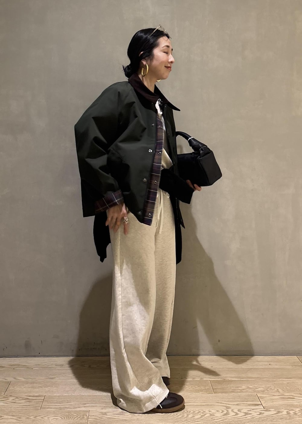 ブラック系のハンドバッグ、グリーン系のその他アウター、ホワイト系のその他パンツを着用したレディースの冬コーディネートの2枚目の写真