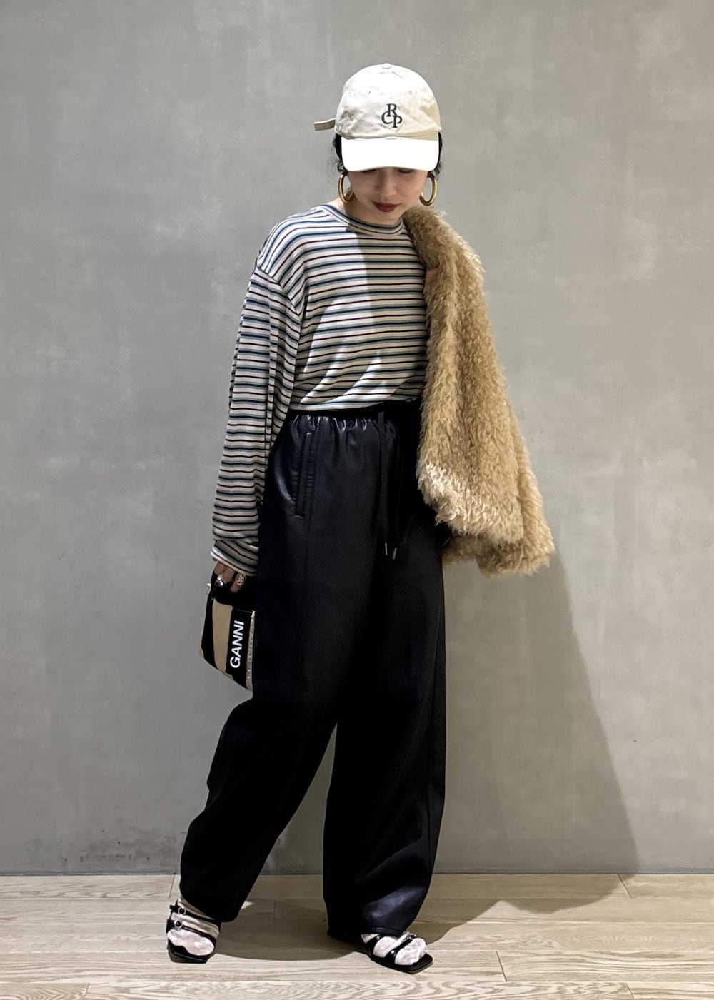 ベージュ系のトートバッグ、ベージュ系のその他アウター、ブラック系のその他パンツを着用したレディースの秋コーディネートの6枚目の写真