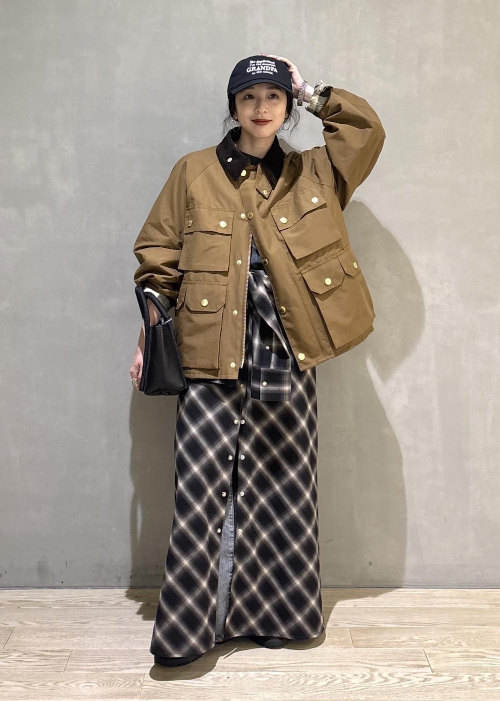 イエロー系のブルゾン、ブラック系のキャップを着用したレディースの秋コーディネートの10枚目の写真