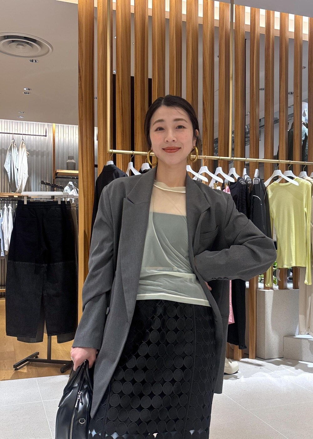 ブルー系のデニムパンツ、グレー系のテーラードジャケット、ブラック系のローファーを着用したレディースの春コーディネートの7枚目の写真
