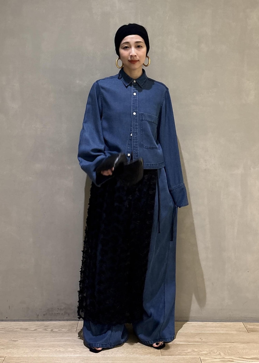 ブルー系のシャツ/ブラウス、ブルー系のデニムパンツ、ブラック系のクラッチバッグを着用したレディースの冬コーディネートの5枚目の写真