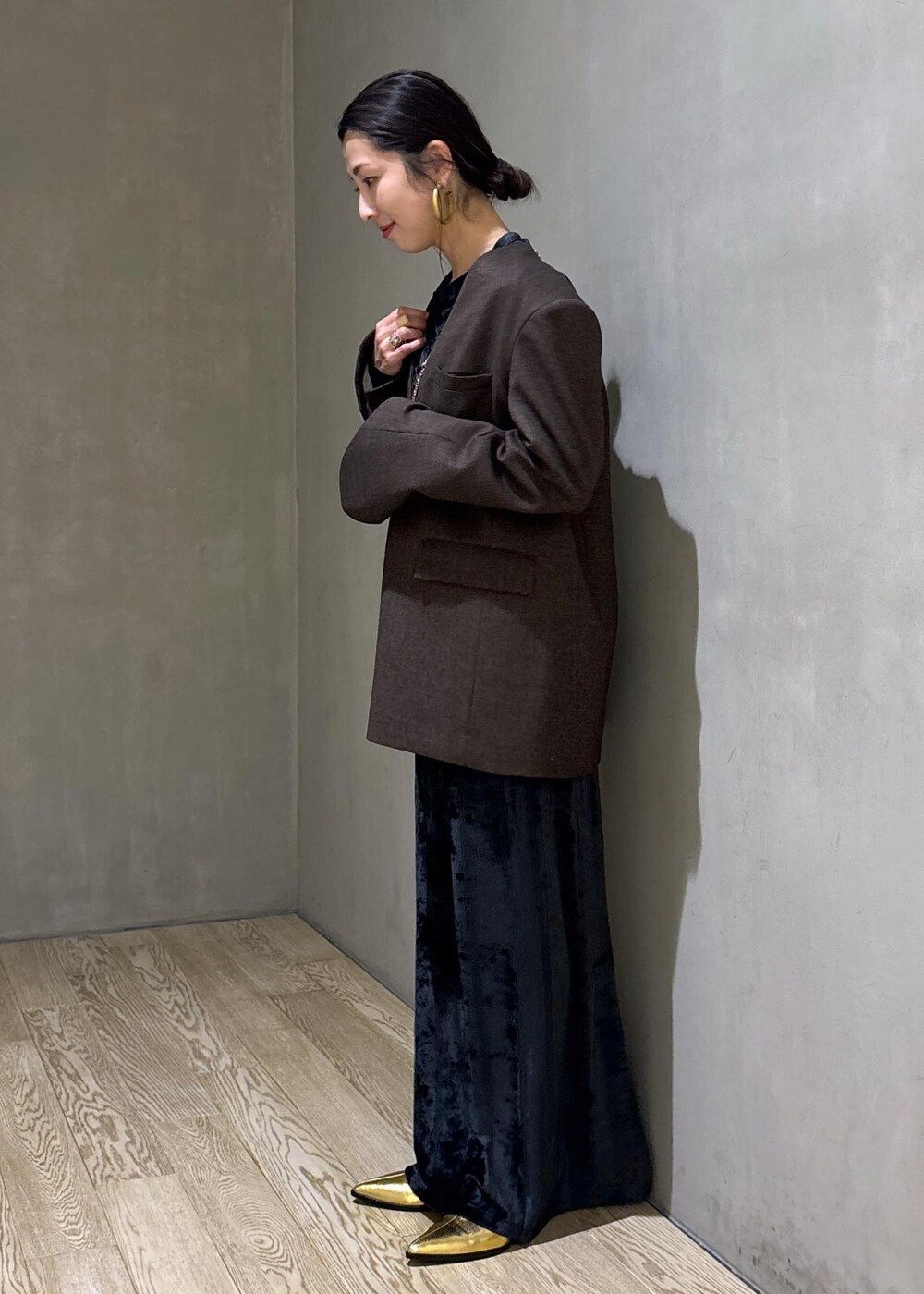 ブラック系のスカート、ブラック系のTシャツ/カットソー、ゴールド系のブーツを着用したレディースの冬コーディネートの6枚目の写真