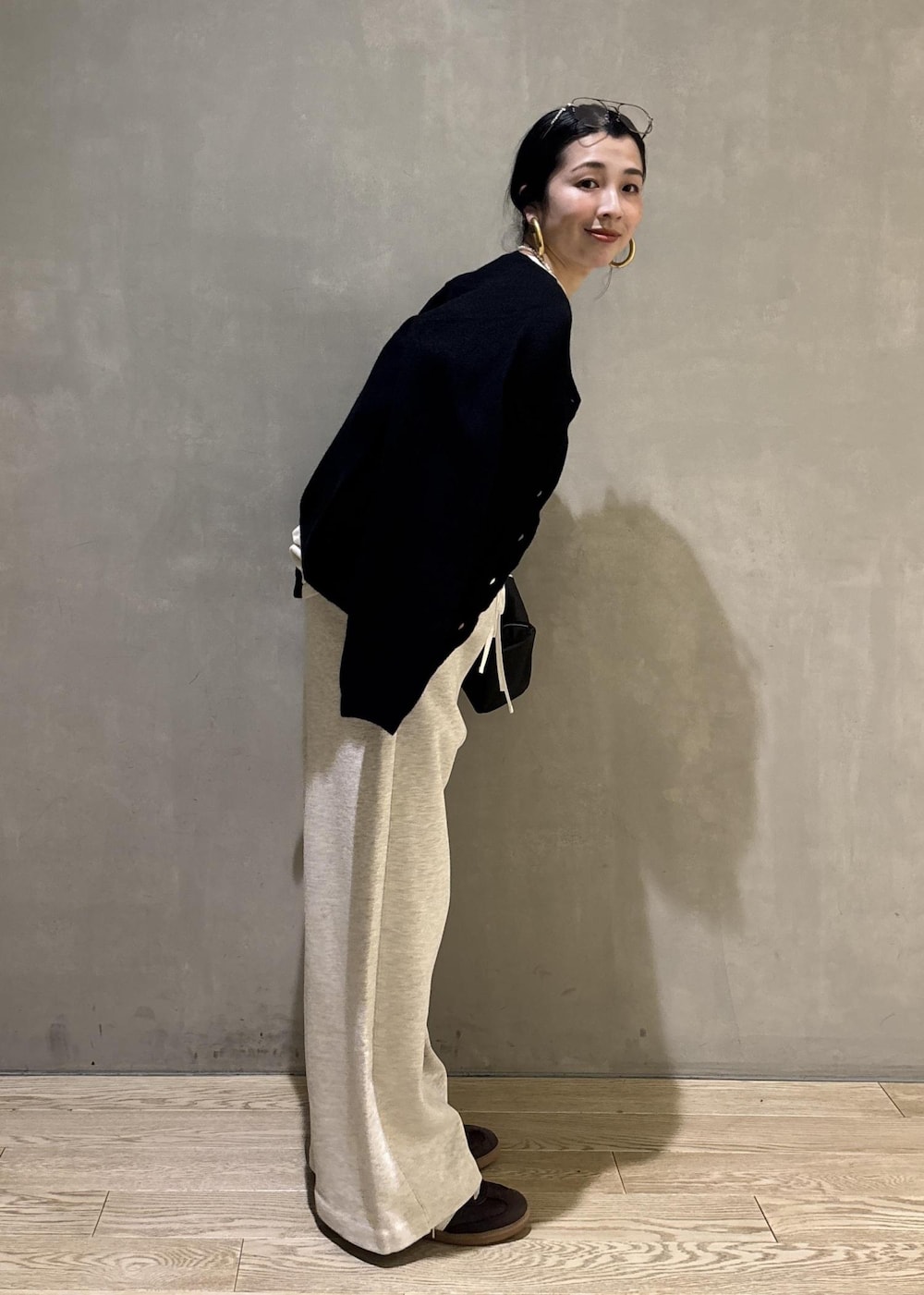 ブラック系のハンドバッグ、ホワイト系のその他パンツ、ホワイト系のスウェットを着用したレディースの冬コーディネートの4枚目の写真