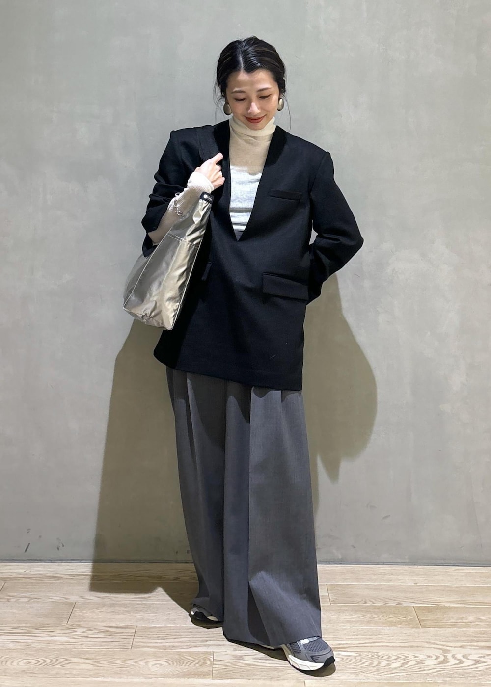 グレー系のスニーカー、ホワイト系のニット/セーター、ブラック系のシャツ/ブラウスを着用したレディースの秋コーディネートの2枚目の写真