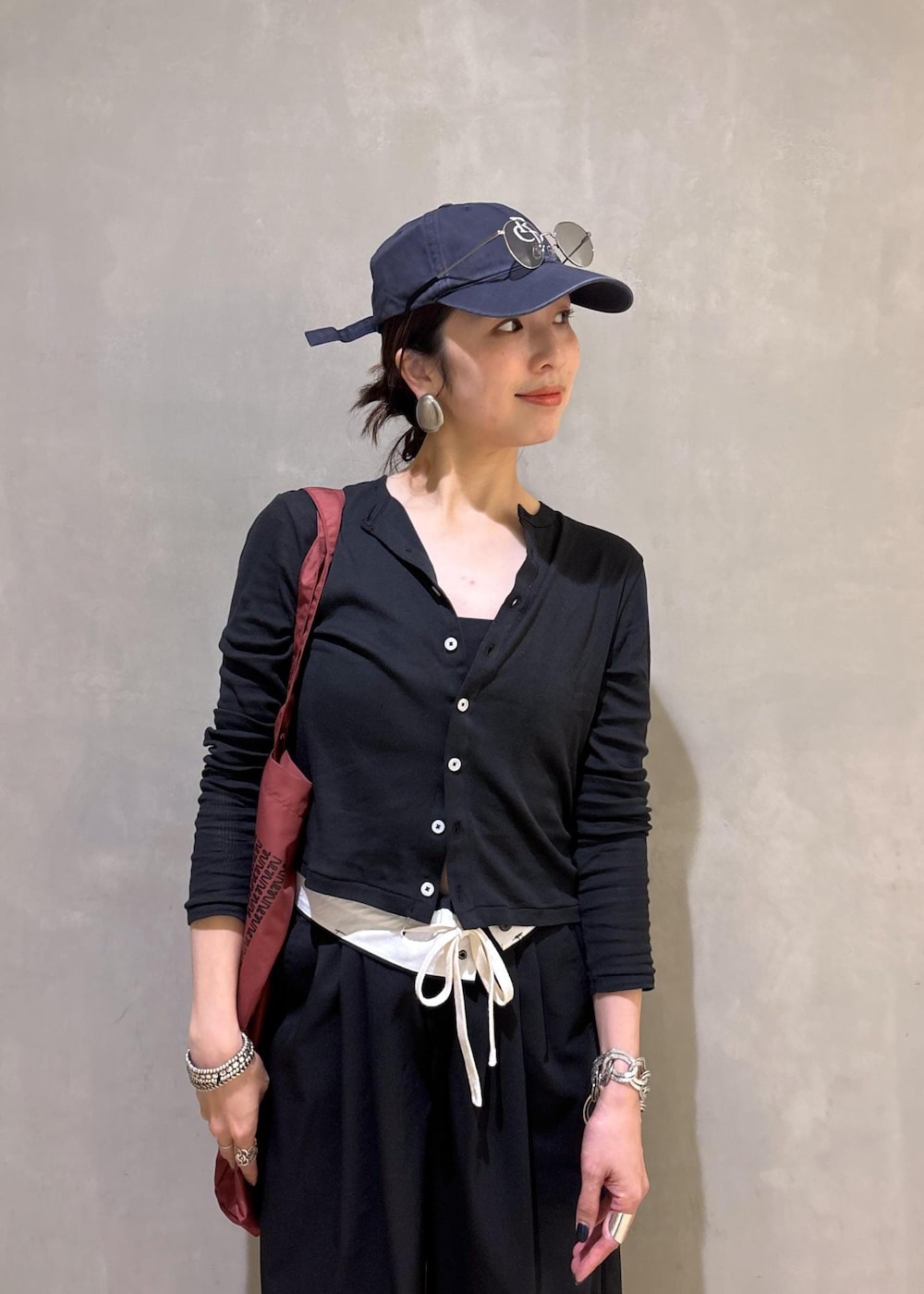 ブラック系のカーディガン/ボレロ、ブラック系のスラックス、シルバー系のサングラスを着用したレディースの夏コーディネートの8枚目の写真