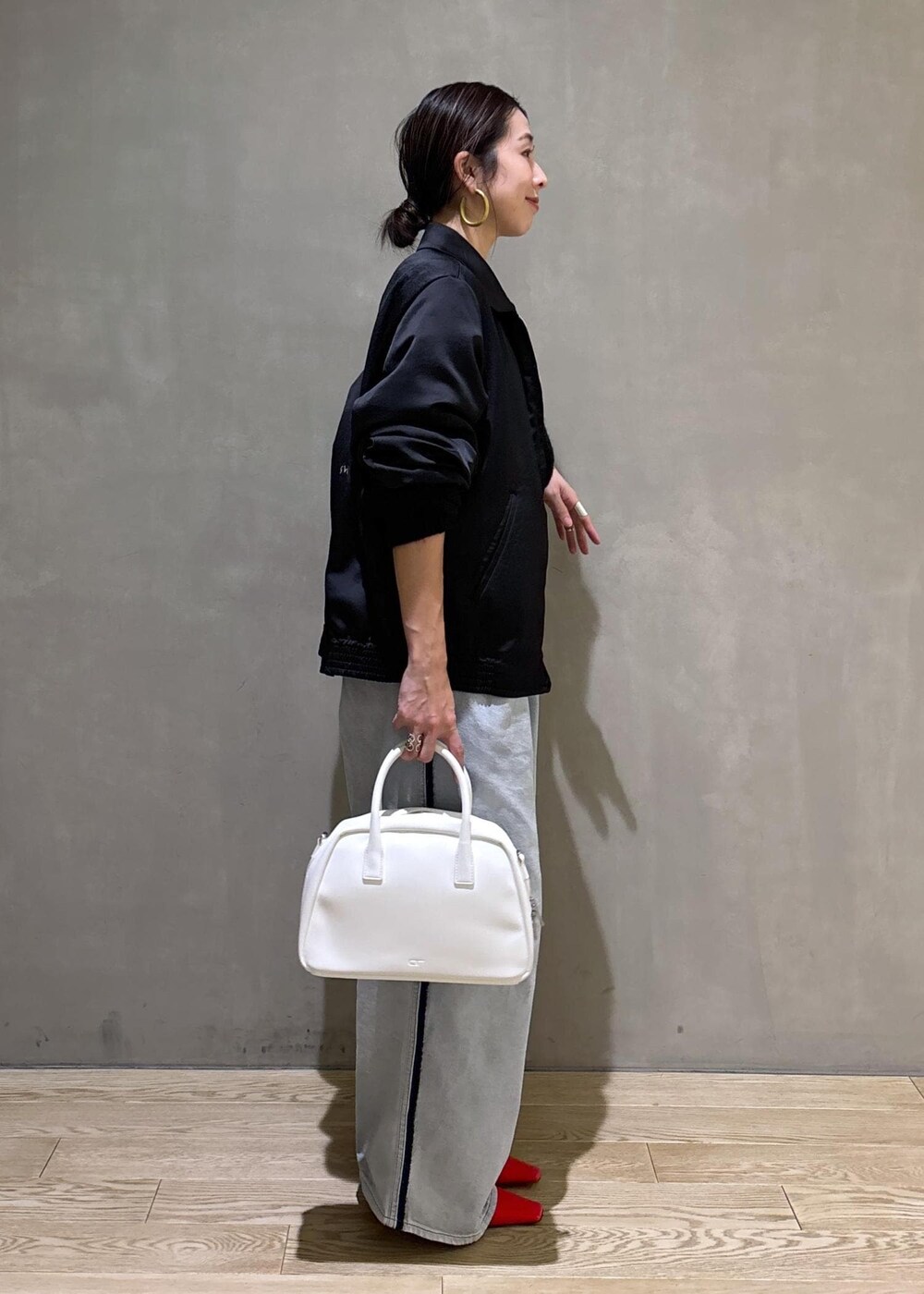 ブラック系のニット/セーター、ホワイト系のボストンバッグ、ブルー系のその他パンツを着用したレディースの冬コーディネートの5枚目の写真