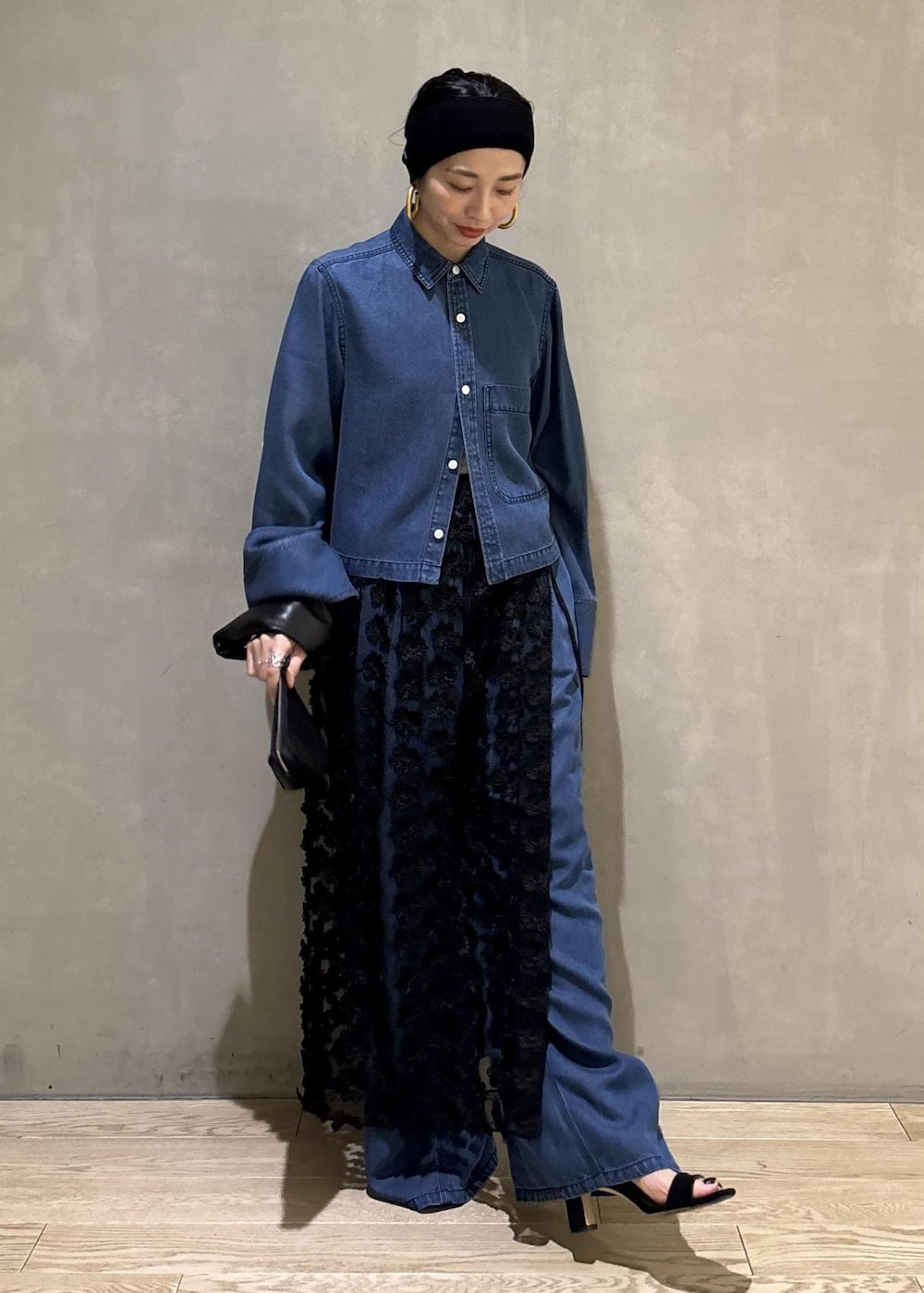 ブルー系のシャツ/ブラウス、ブルー系のデニムパンツ、ブラック系のクラッチバッグを着用したレディースの冬コーディネートの2枚目の写真