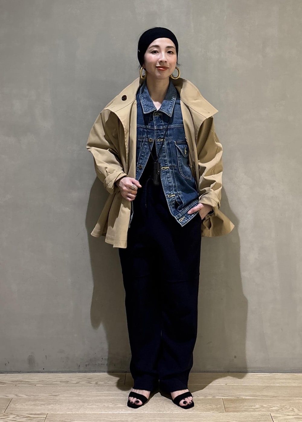 ベージュ系のトレンチコート、ブルー系のデニムジャケット、ブルー系のその他パンツを着用したレディースの春コーディネートの2枚目の写真