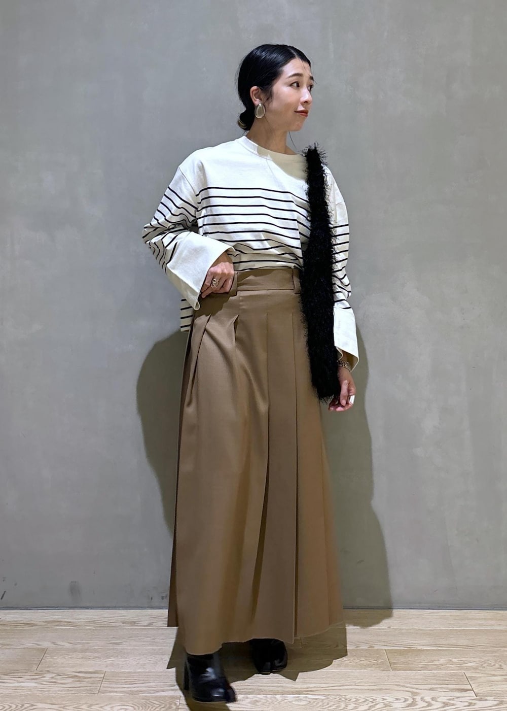 ベージュ系のスカート、ホワイト系のTシャツ/カットソー、ブラック系のハンドバッグを着用したレディースの夏コーディネートの3枚目の写真