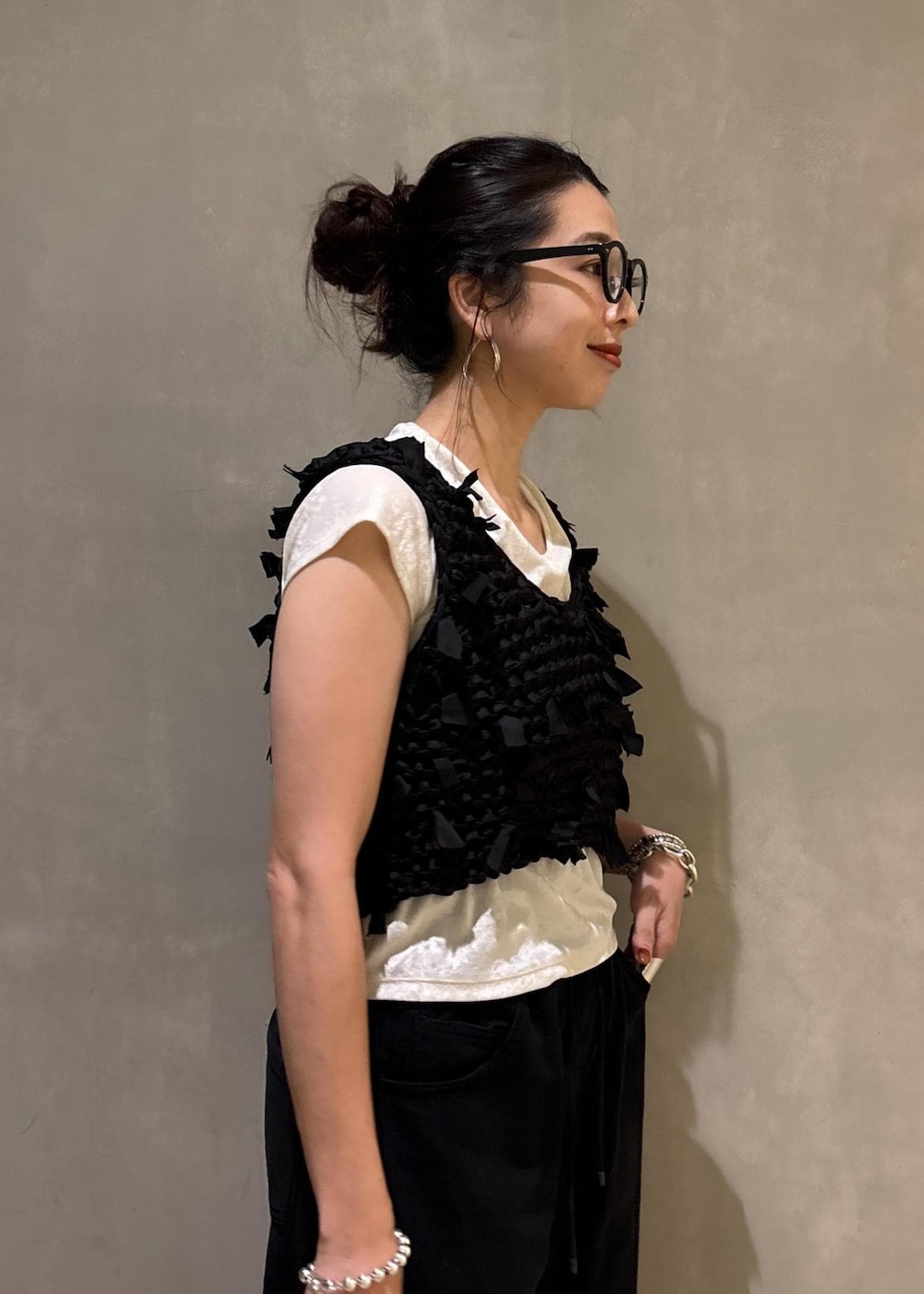 ホワイト系のTシャツ/カットソー、ベージュ系のショルダーバッグ、ブラック系のベストを着用したレディースの夏コーディネートの9枚目の写真