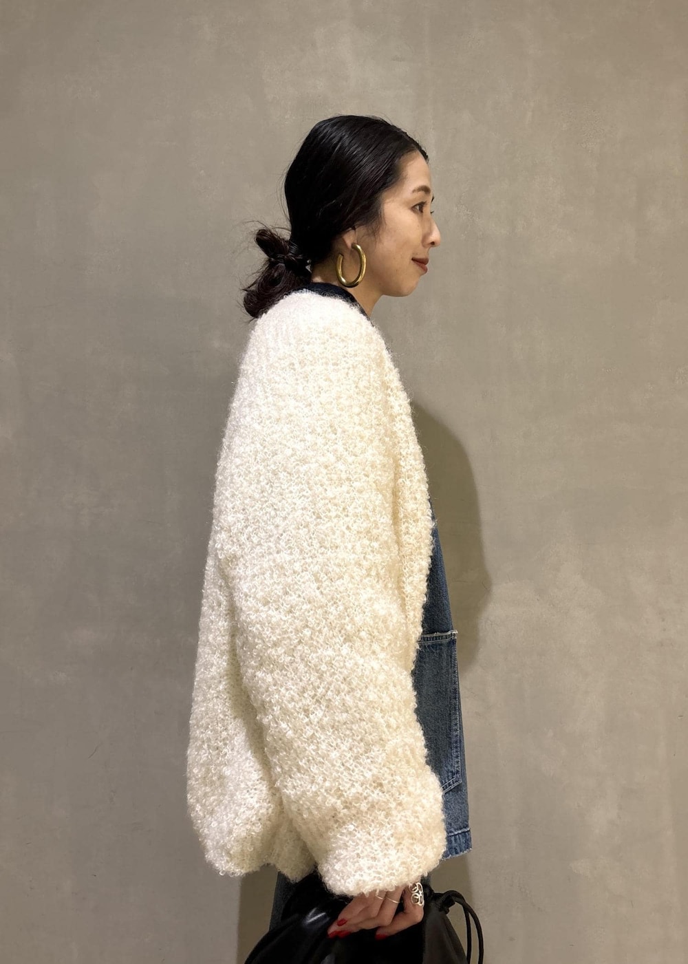 ブラック系のショルダーバッグ、ブルー系のデニムパンツ、ブルー系のカバーオールを着用したレディースの秋コーディネートの8枚目の写真